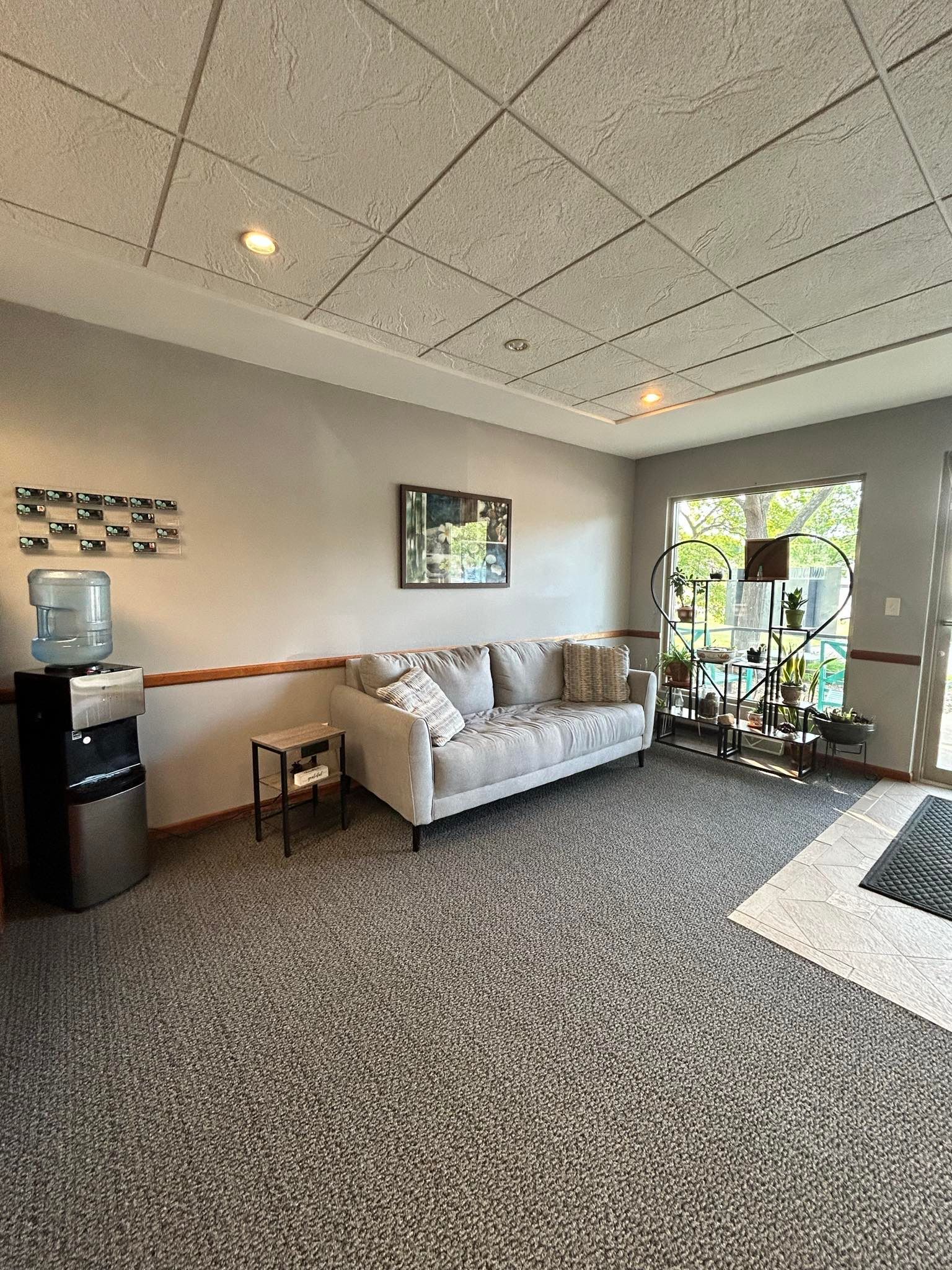 A living room with a couch and a water cooler.