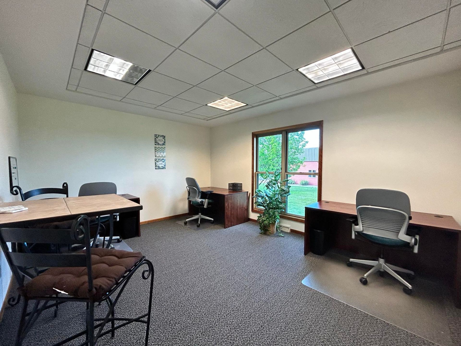 There are three desks and chairs in the room.