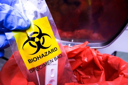 A person is holding a biohazard specimen bag