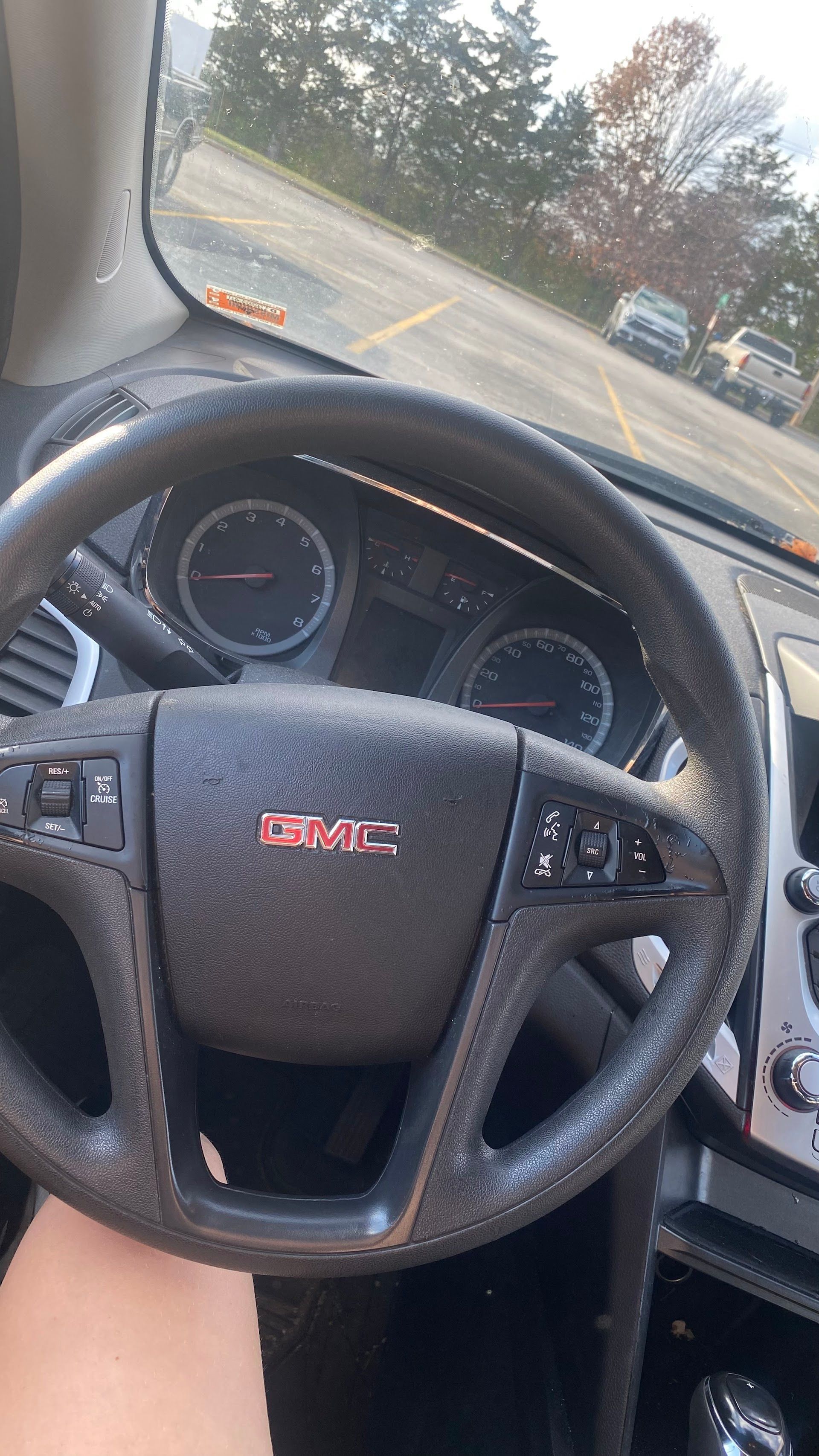 Driver’s seat view of a GMC steering wheel and dashboard, with road  visible through the windshield. | Oak Auto
