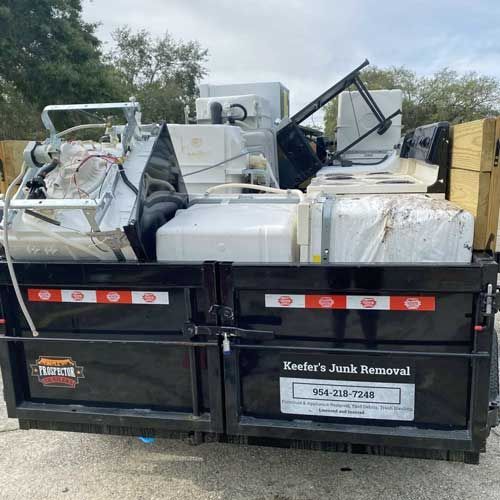 A trailer filled with appliances is parked in a parking lot.