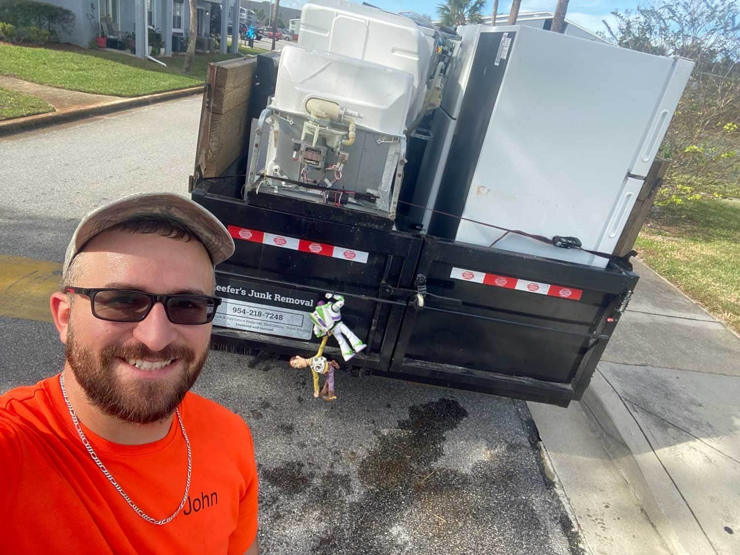 John Keefer is standing in front of a trailer filled with removed appliances.