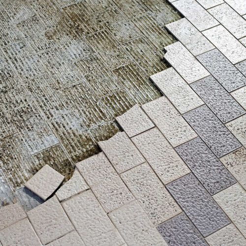 Construction: Partially tiled surface; tiles in two shades of grey, with exposed mortar base.