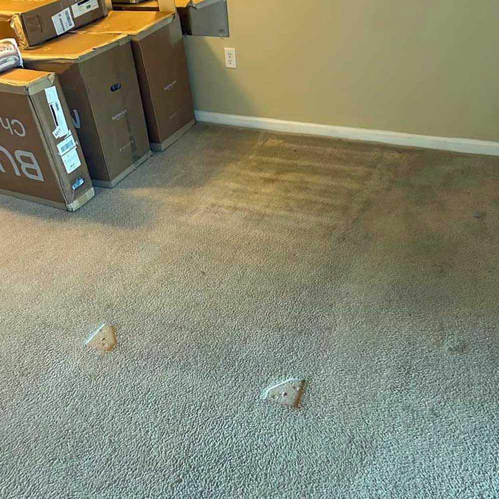 A room with a carpet and boxes on the floor