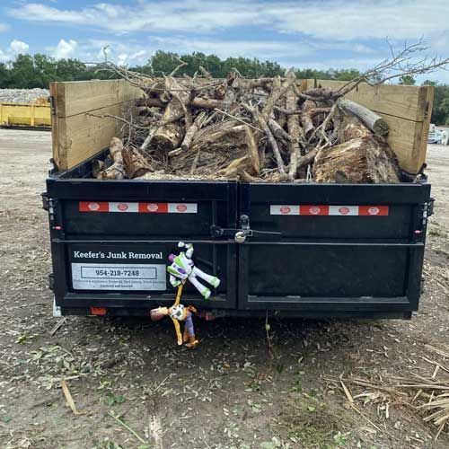 A Keefer's Junk Removal trailer filled with wood after a storm clean up.