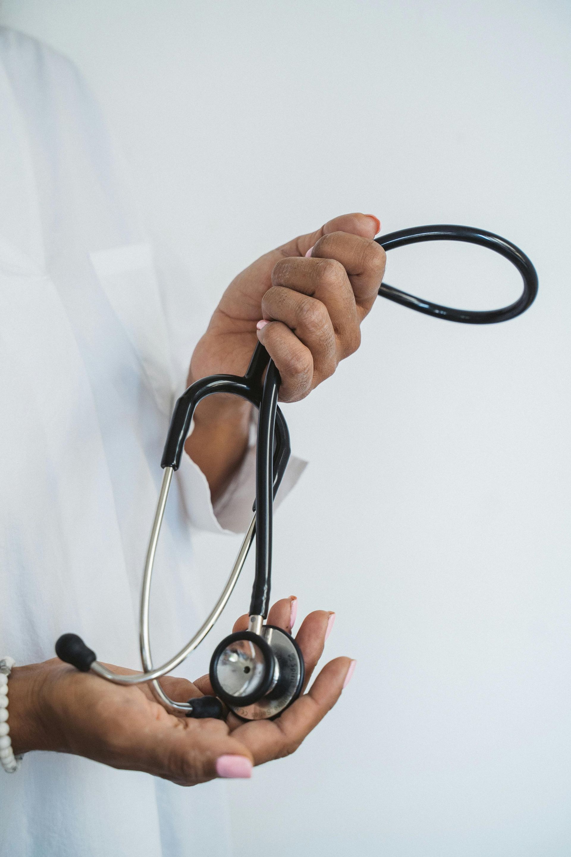 Person holding a stethoscope; a medical professional.