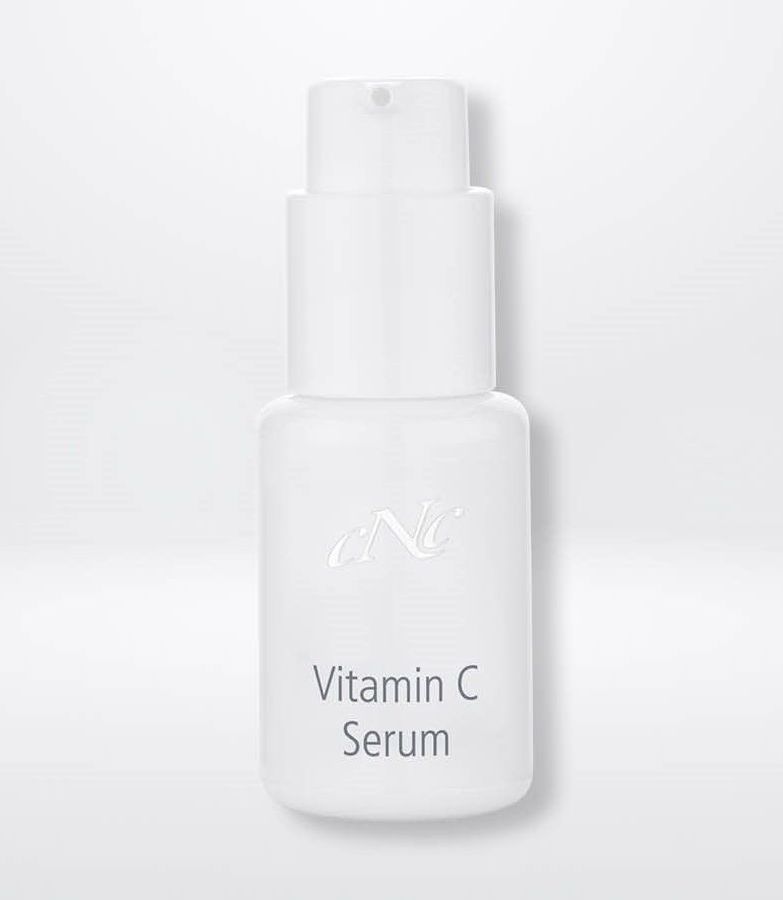 Eine weiße Flasche Vitamin-C-Serum steht auf einer weißen Oberfläche.