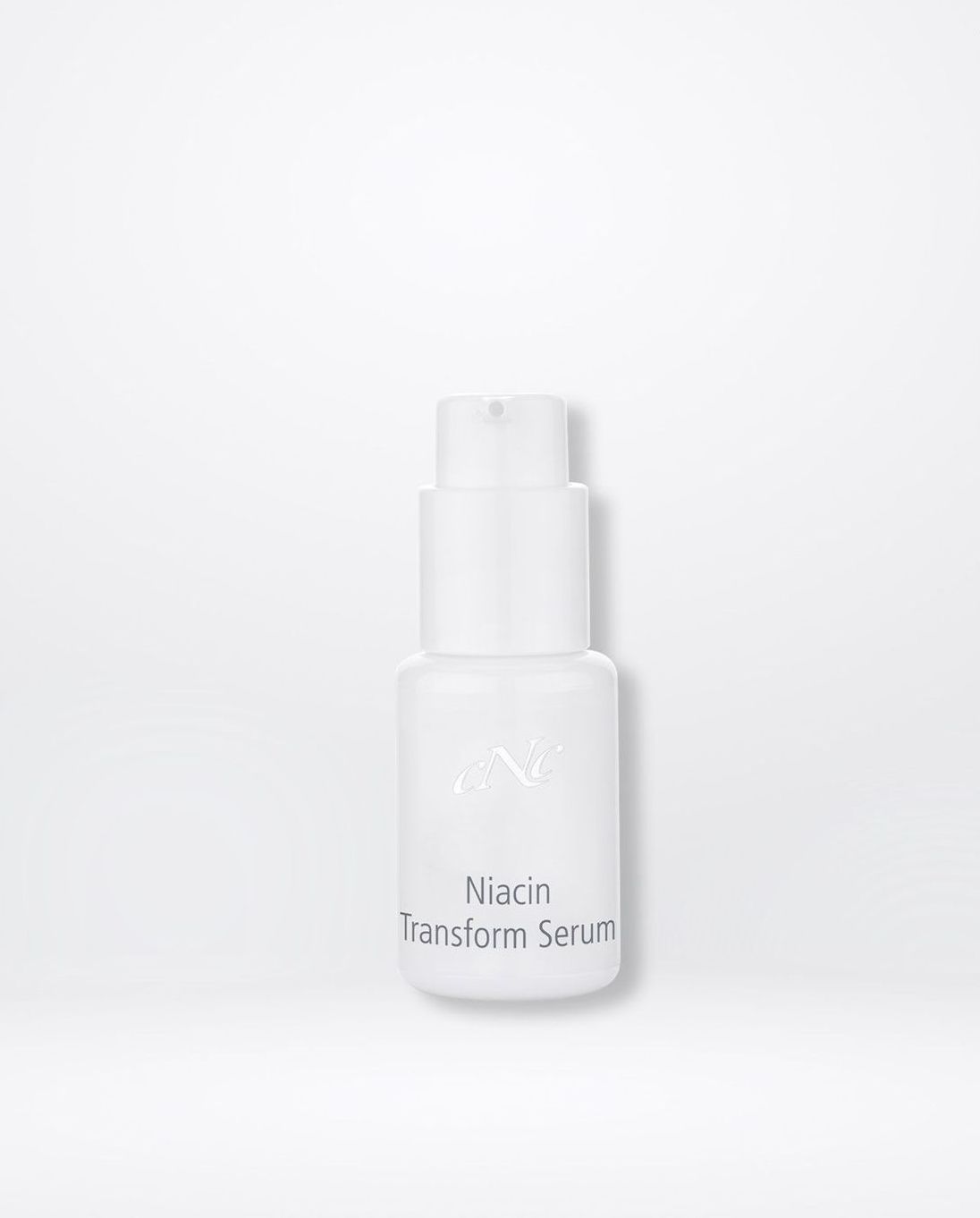 Eine weiße Flasche Serum steht auf einer weißen Oberfläche.