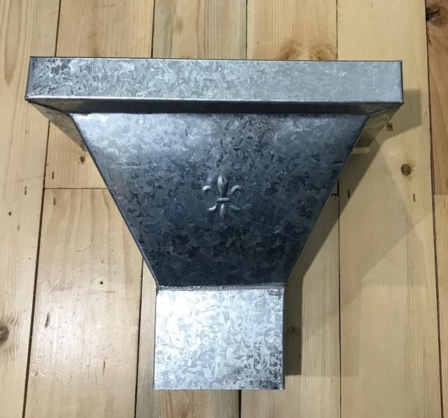 Conexión de conducto en forma de embudo de metal galvanizado sobre un suelo de madera