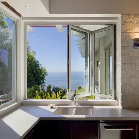 Kitchen with open folding windows overlooking ocean view.