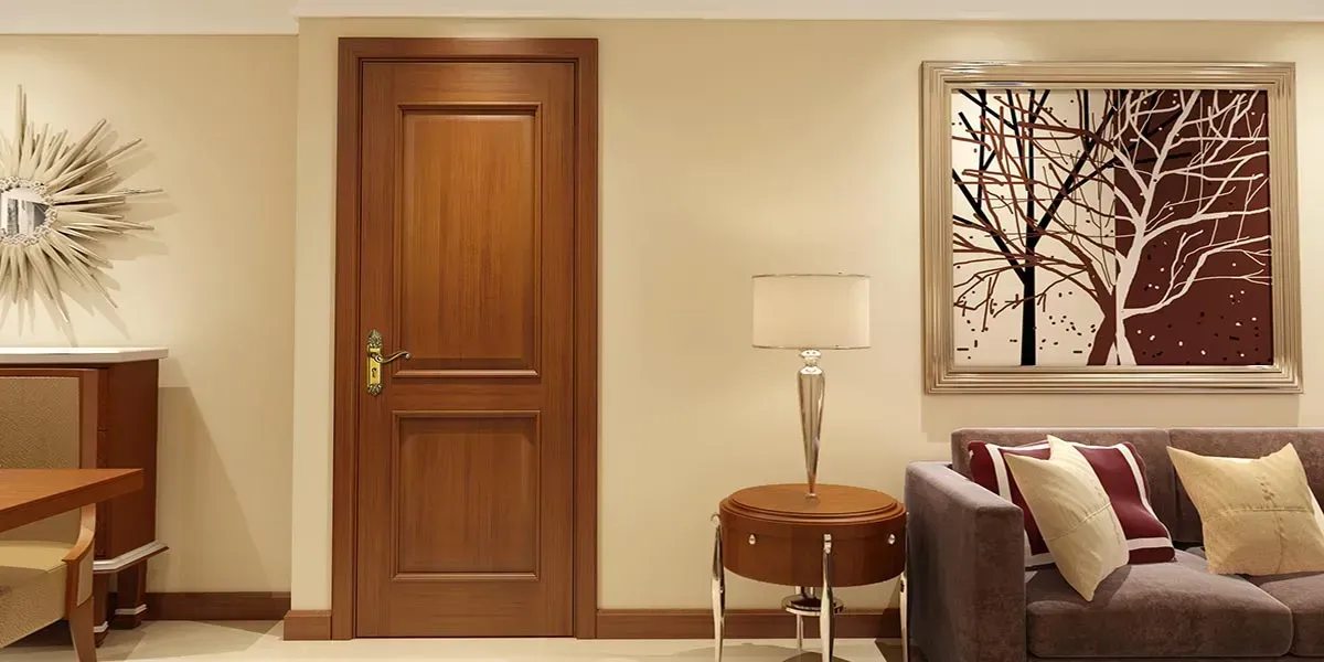 A wooden door centered between a wall with a sofa and a table with a lamp.