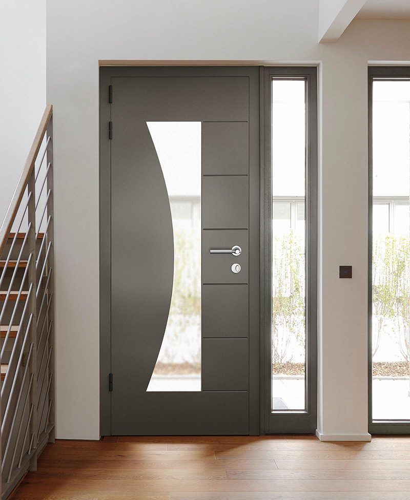 Dark gray front door with decorative glass panel, sidelight, and wood floors.