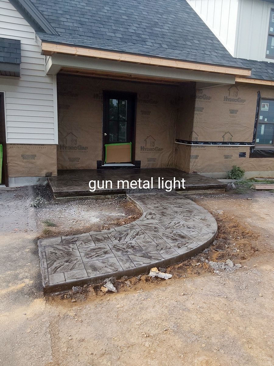 A concrete walkway is being built in front of a house.