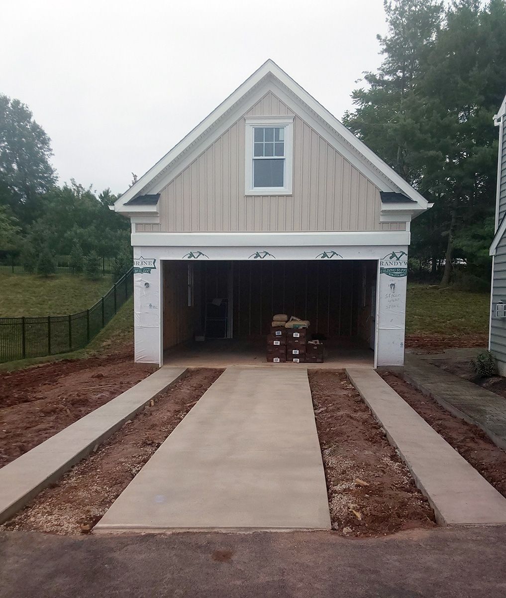 A garage with a concrete driveway leading to it
