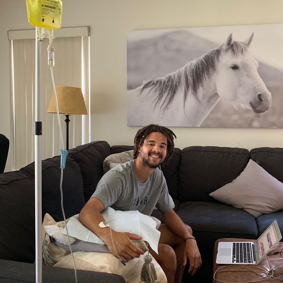 A man is sitting on a couch in front of a picture of a horse