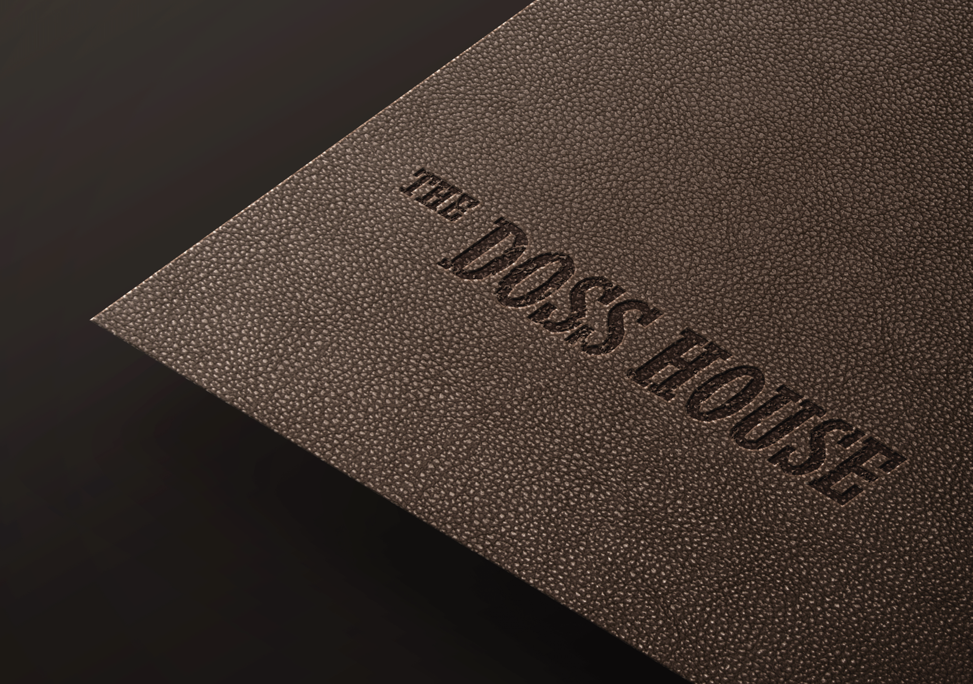 A textured brown leather cover for The Doss House menu featuring embossed typography, designed by The End Creative Agency.