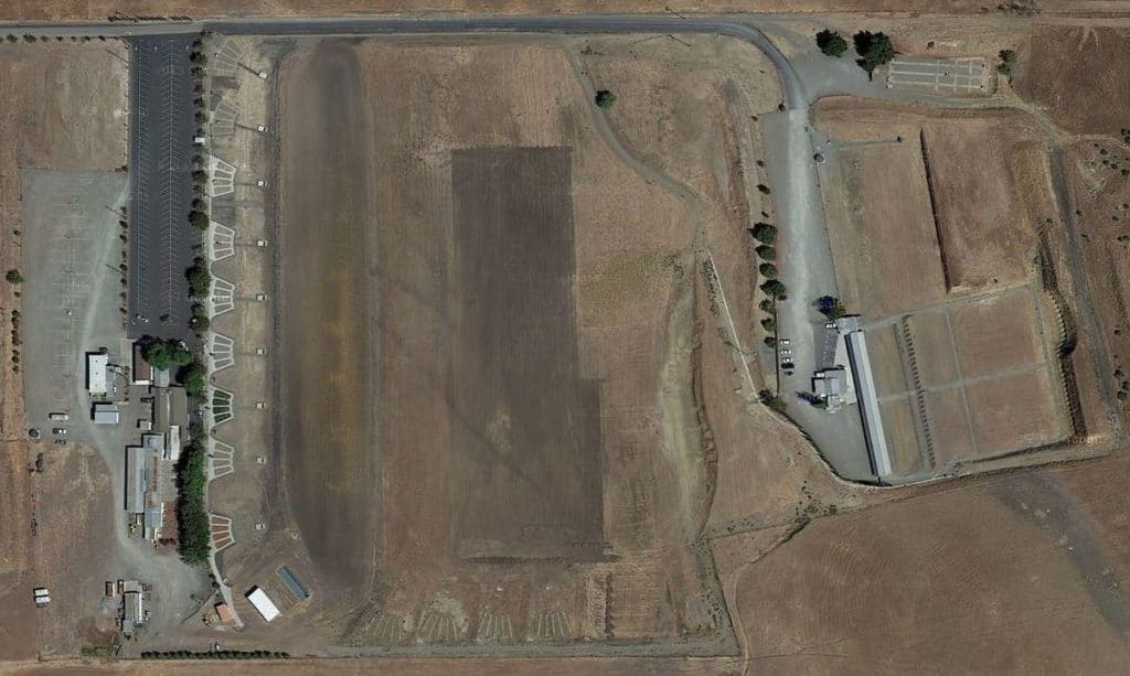 An aerial view of a large field with a road going through it