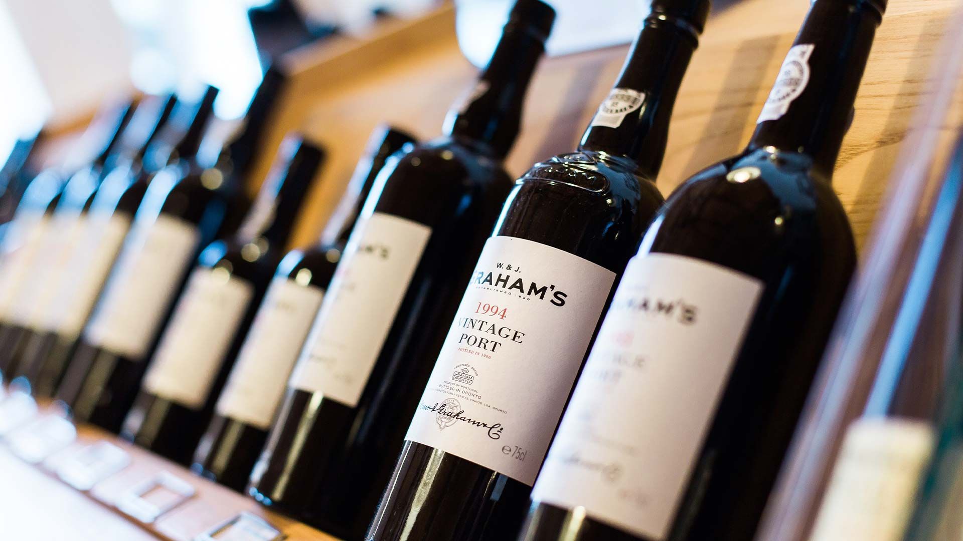 Several bottles of Adam's wine are lined up on a shelf.