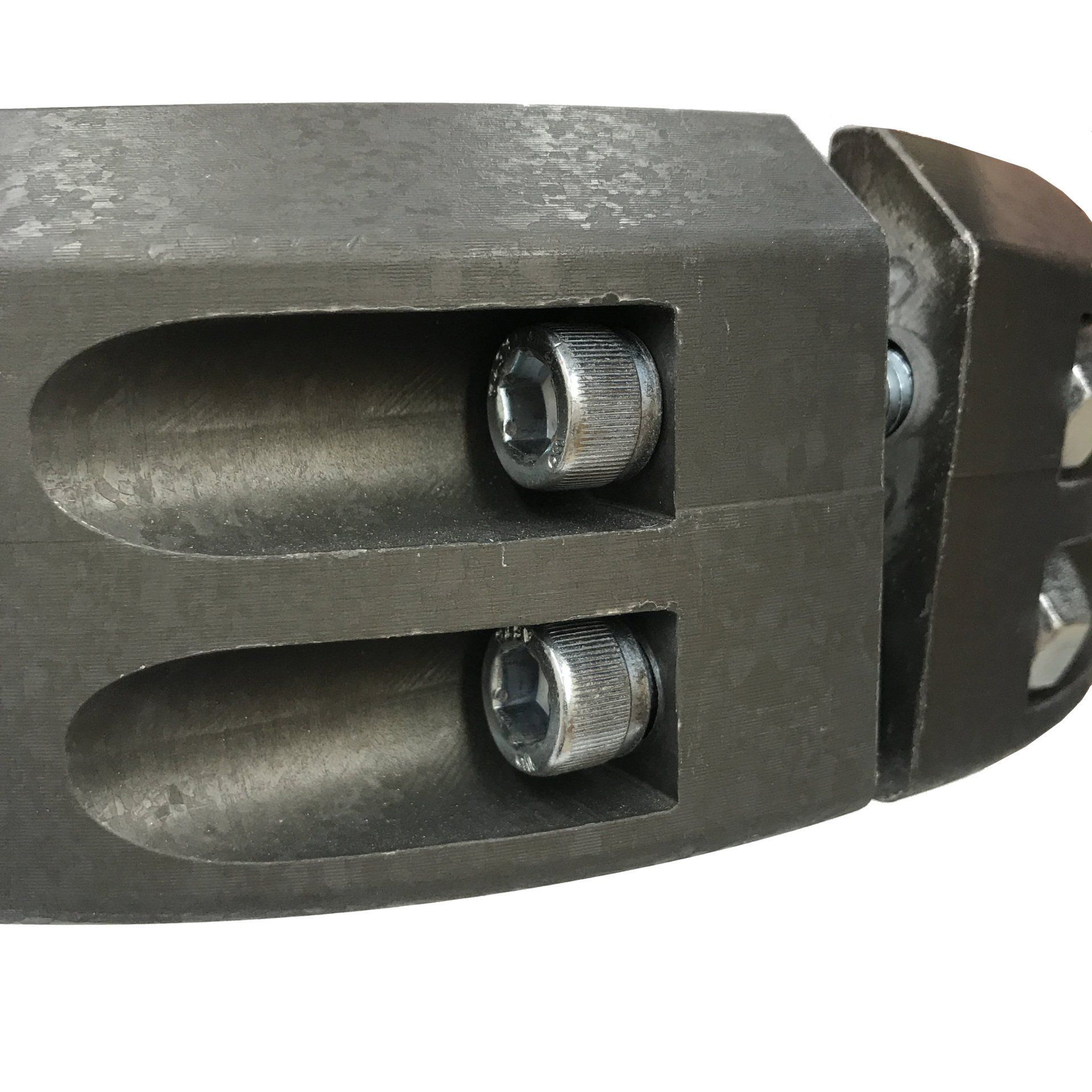 Close-up of a dark metal clamp with two visible bolts inside recessed slots