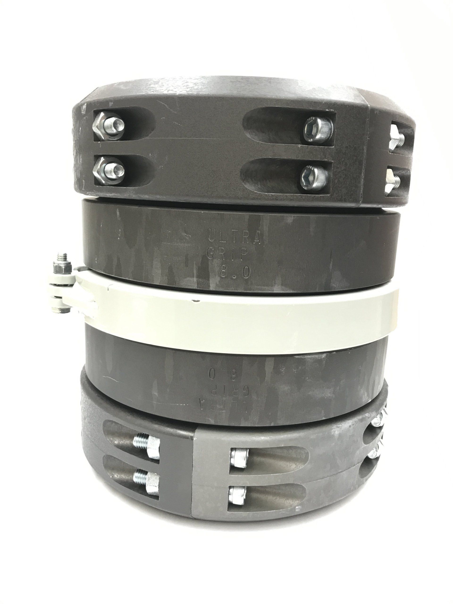 Stacked black and white cylindrical mechanical part with visible bolts and clamps