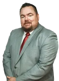 A man in a grey suit and tie is standing with his hand in his pocket. A man in a grey suit and tie is standing with his hand in his pocket.