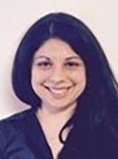 Smiling person with long dark hair against a light background