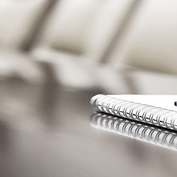 Close-up of a spiral notebook on a glossy table with a blurred background