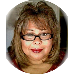 Portrait of a woman with shoulder-length brown hair, glasses, and red lipstick, smiling slightly