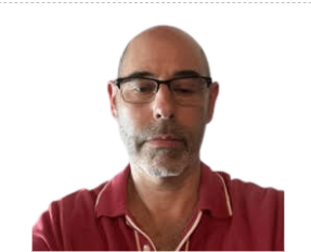 Man wearing glasses and a red polo shirt against a white background