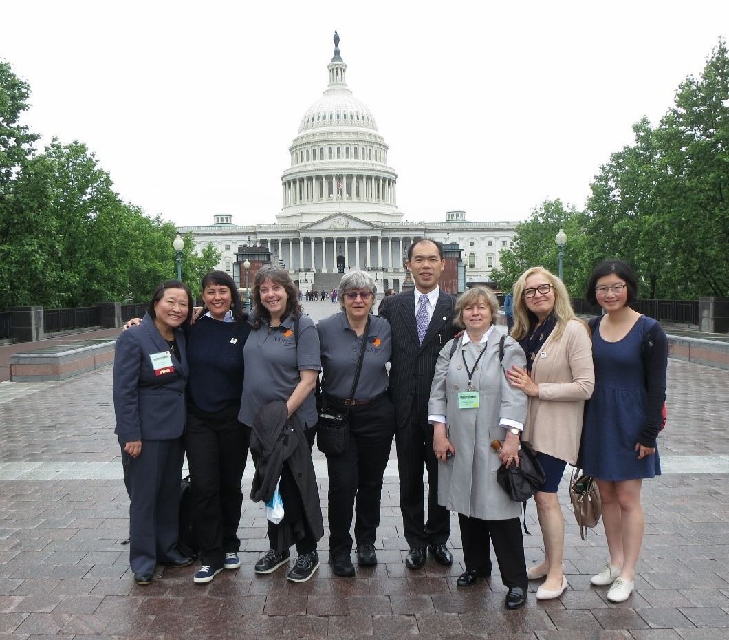 Group of people posing on a walkway in front of the U.S. Capitol building