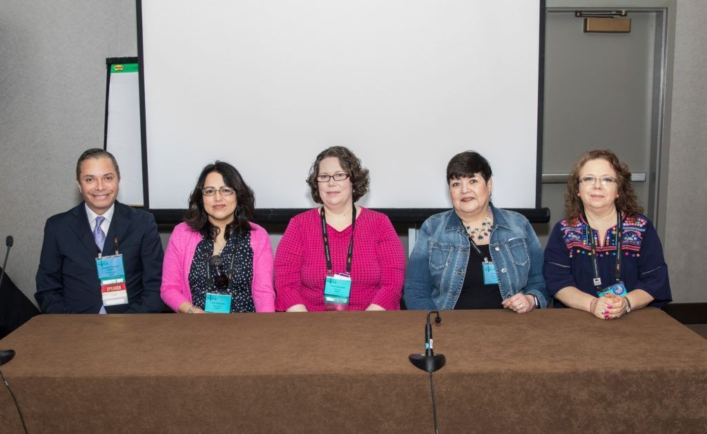 Five people seated behind a conference table in a meeting room, facing the camera.