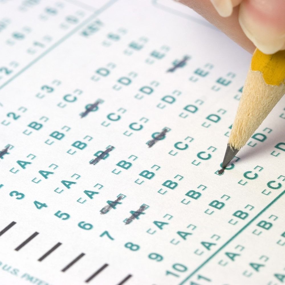 Pencil marking answers on a multiple-choice test sheet with bubbles and letters visible