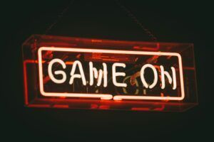 Glowing red neon sign reading “GAME ON” against a dark background