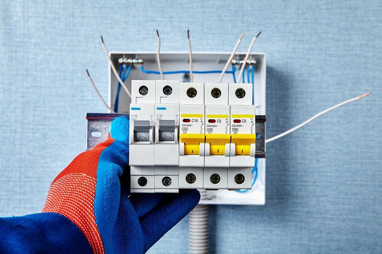 A person is holding a circuit breaker in their hand.