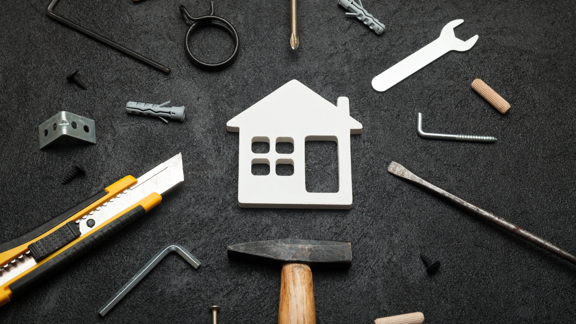 There is a model of a house surrounded by tools.