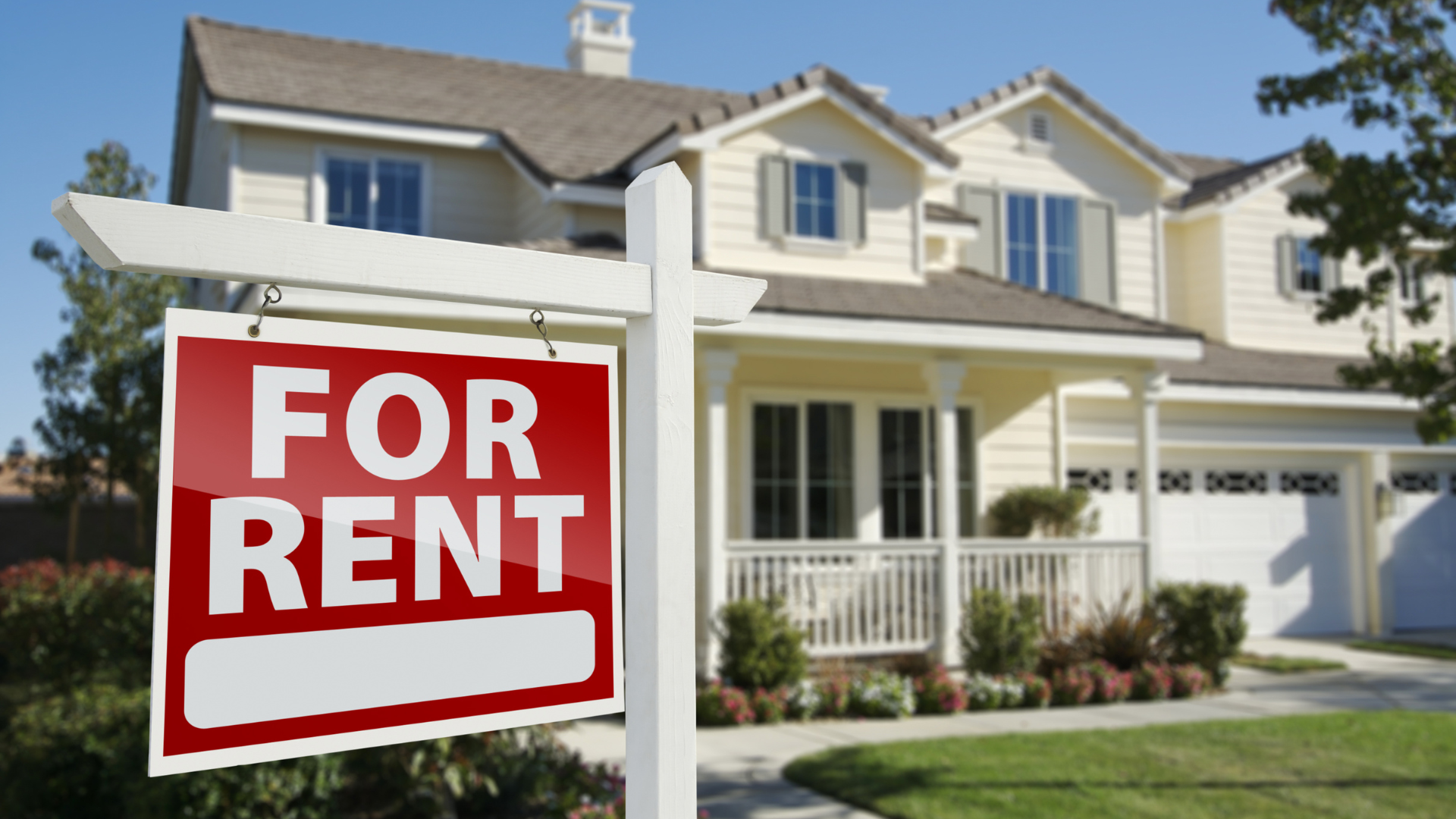 A house with a for rent sign in front of it