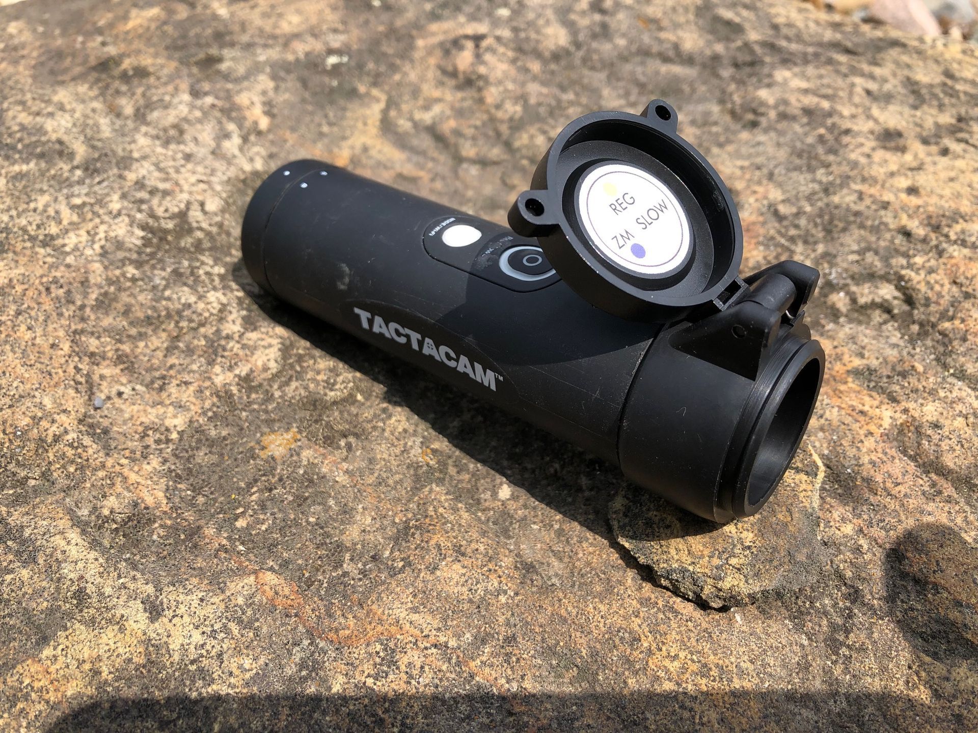 A black object is sitting on top of a rock.