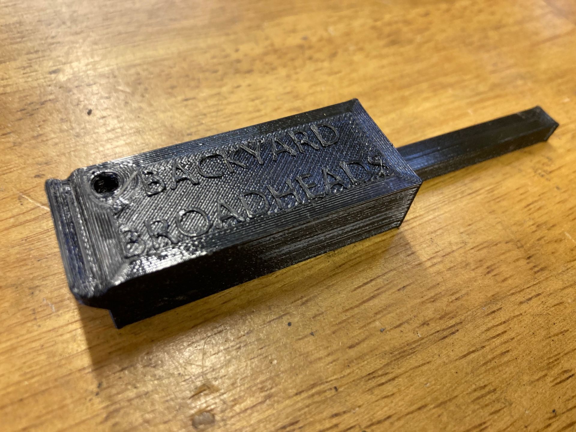 A black object is sitting on a wooden table.