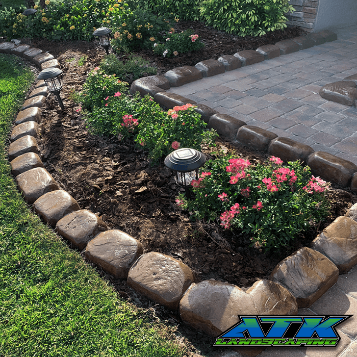 A garden with flowers and a walkway with atk written on the bottom