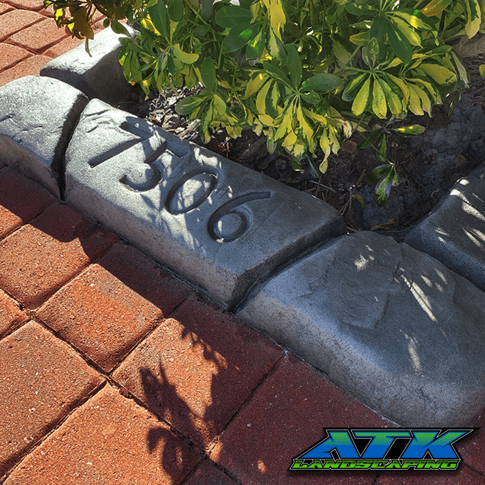 A brick curb with the number 1366 on it