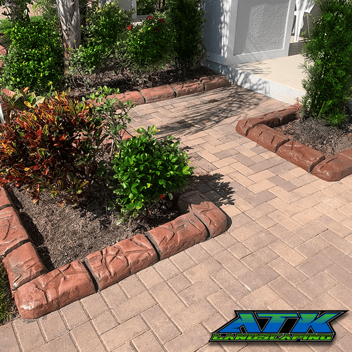 A brick walkway surrounded by plants and bushes.