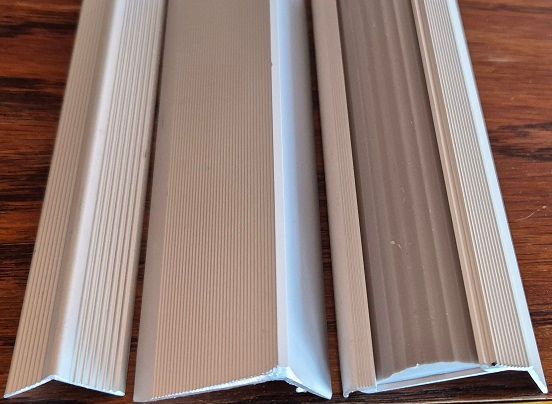 Three pieces of metal are stacked on top of each other on a wooden table.