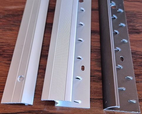 Three pieces of metal are sitting on a wooden table
