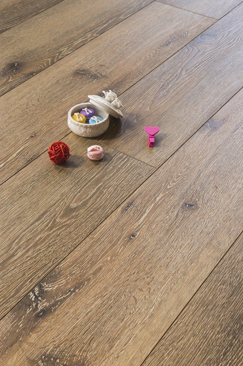 A wooden floor with a bowl of candy on it.