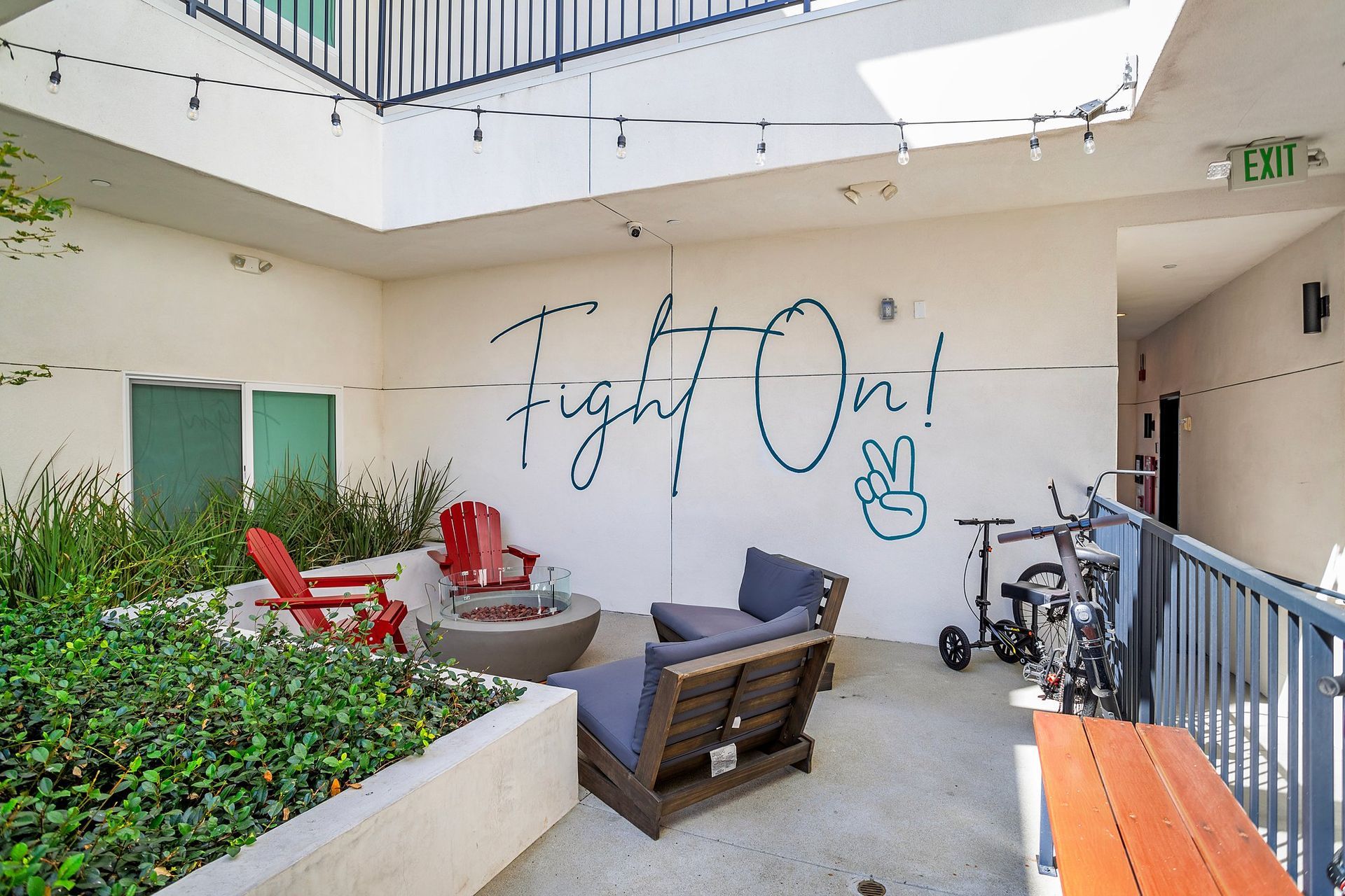 Courtyard lounge with fire pit and Fight On mural at Oasis at the Row near USC