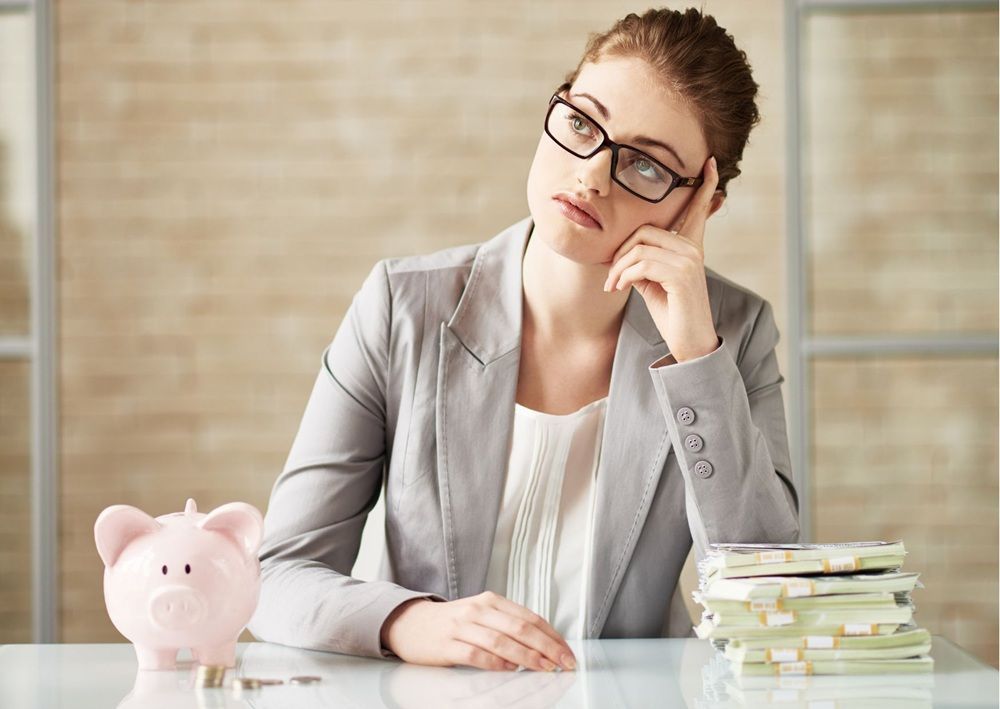 Woman reviewing finances with piggy bank and documents while considering safe rental decisions.