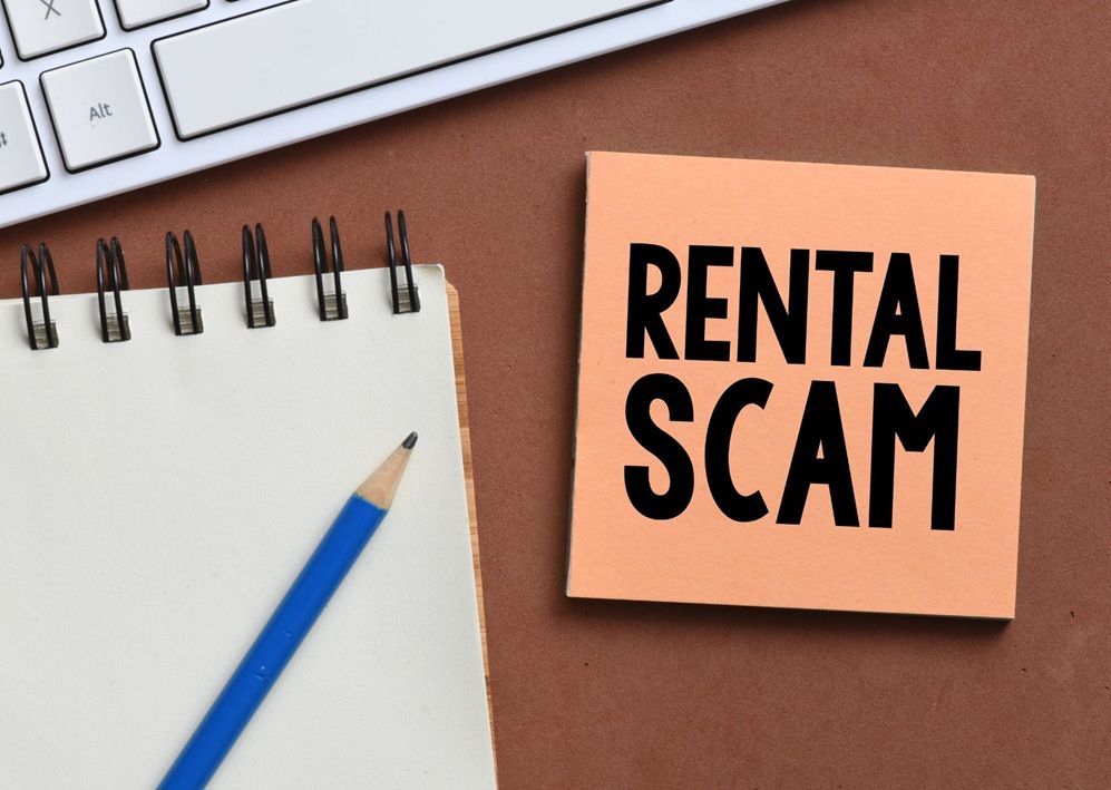 Notebook & rental scam note highlighting the importance of verifying listings before sending money.