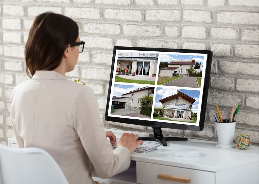 Person comparing rental property listings on a computer to identify legitimate housing opportunities.