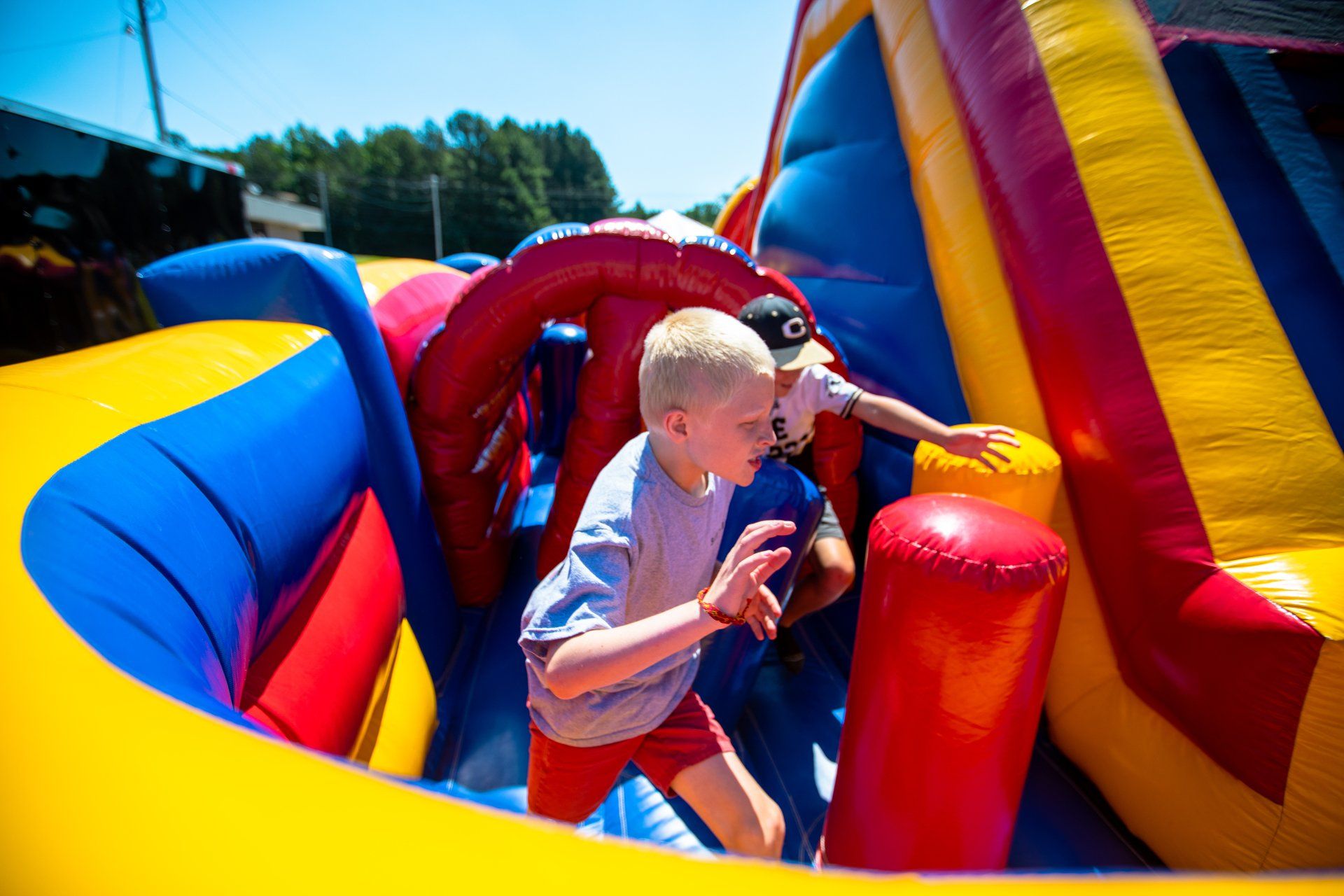A boy is playing in an inflatable obstacle course.