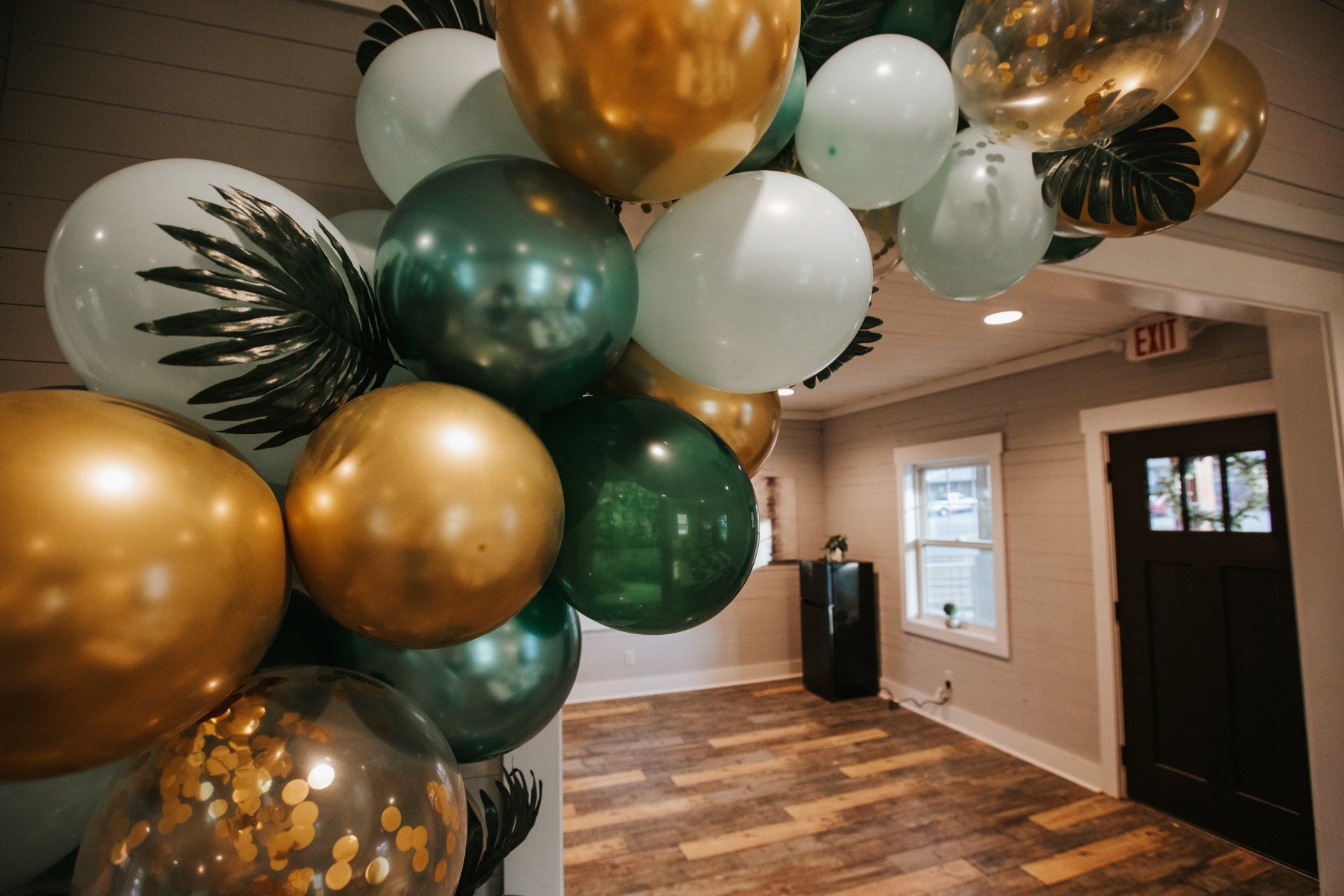A bunch of balloons are hanging from the ceiling in a room.
